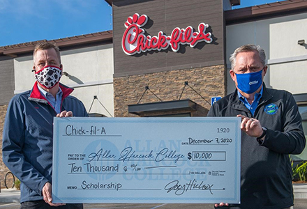 A check is presented to Hancock Superintendent/President Kevin G. Walthers, Ph.D from Chick-fil-A at Enos Ranch owner/operator Joey Hickox.